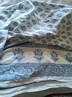 Blue and white cotton tablecloth showing floral block print patterns and border designs.