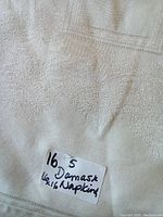 Close-up photo showing the woven floral and geometric damask pattern and a label stating quantity (5) and size (16 inches).