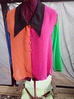 Front view of colour block long sleeve blouse with large black collar showing orange, pink, green and blue colors and front buttons.