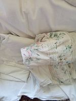 Photo of white double flat sheets folded and stacked; sheets plain white fabric