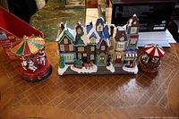 Overview of two musical carousels and the row house on a table showing their sizes and general appearance.