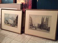 Shows two framed Victorian prints leaning against a wall, highlighting the matching gold gilt frames and overall size.