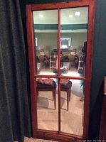 Full view of the large antique window mirror showing the bowed wooden frame and four rectangular glass panes.