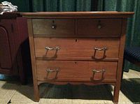 Front view of wooden dresser with 6 drawers, showing metal handles and keyed locks on drawers.