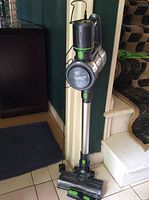Full view of the Toppin cordless stick vacuum cleaner standing upright with visible suction head, handle, and dust container.