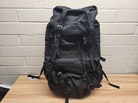 Front view of the black Fieldline Delta tactical hiking pack showing multiple MOLLE webbing rows and compression straps.