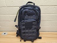 Front view of black Fieldline hydration pack showing main zippered compartments and MOLLE webbing on front.