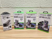 Four boxed Chargeworx items displayed in a row on a table against a white wall: one dual USB car charger and three phone mounts (two universal dash mounts and one magnetic air vent mount).