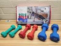 Front view of six colorful dumbbells in three weights arranged in front of original Pro-Form box