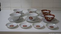 Front view of Taiwan Tatung fine china tea set including cups, saucers, and small dishes arranged on a white surface.