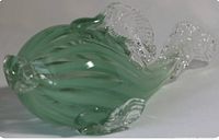 Side view of the green glass fish sculpture showing ribbed texture and clear fins.