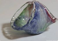 Close-up angled photo showing the swirling colors and scalloped edge of the Murano glass basket