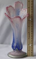 Front angled photo showing the floral shaped top of the vase with blue and pink swirls, next to a ruler for scale, approximately 12 inches tall.