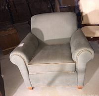 Front view of Norwalk fabric upholstered armchair showing the rolled arms, cushioned seat and backrest with piping details.