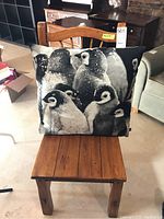 Penguin printed cushion placed on the wood side chair.