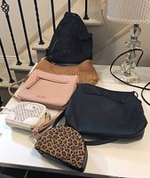 Set of six purses including black backpack purse, natural woven tote, pink crossbody, blue leather purse, white purse with silver embellishments, and leopard print pouch
