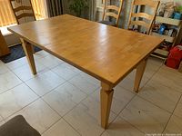 Table fully set up showing rectangular shape and wooden parquet-style top surface.