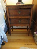 Full front view of the antique table showing both drawers and turned legs