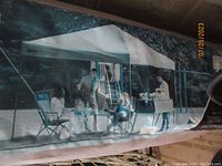 Photo of the canopy tent assembled with people under it showing size and use