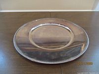 Top view of the silver plated Christofle Fleuron tray showing circular design and shiny surface with faint reflections.