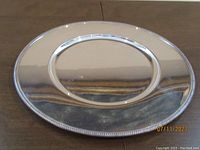 Top view of the Christofle Fleuron round silver plated tray showing the bright polished center and beaded edge.