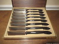 Eight serrated steak knives arranged in original Cutco presentation box