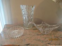 Photo showing all three items on a marble surface: crystal vase, cut glass bowl, and clear glass centerpiece bowl.