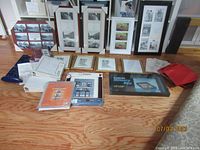 Wide view of assorted picture frames, photo albums, notebooks, and memory boxes laid out on floor.