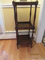 Full view of smaller 3-tier display table showing turned legs and square shelves.