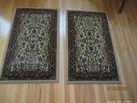 Two Persian Style Kashan design rugs laid on hardwood floor
