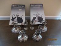 Full view of all sterling silver items including salt and pepper shakers, candle holders, and silver care mitts.