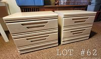 Two white wood night stand side tables showing front with integrated horizontal handles carved out of drawer fronts