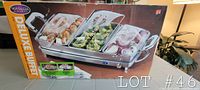 Box showing Nostalgia Electrics Deluxe Buffet product name and image with three serving pans on warming tray.