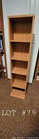 Front view of wooden book/CD stand showing 4 main shelves and multiple smaller shelves.