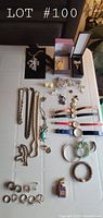 View of entire collection arranged on table showing watches, bracelets, brooches, necklaces, rings, and earrings with some items in boxes