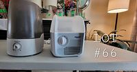Photo showing both the Equate humidifier and Sunbeam dehumidifier on a table with control dials visible