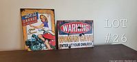 Both metal signs displayed together on a table, showing retro designs and dimensions.