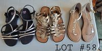 Five pairs of women's casual summer sandals and flip flops laid out on a table, showing various styles including black strappy, brown gladiator, and tan thong sandals with silver accents.