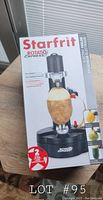 Photo of the front of the box for the Starfrit Rotato Express electric potato peeler featuring a peeled potato on the device stand and product branding.
