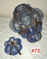 Two Italian blown glass lanterns, one large and one small, each with blue scavo-finished glass panels secured by rusted metal wire frameworks.