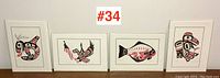 Four framed prints displayed side by side against white wall, numbered #34