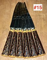 Top view of six steak knives fanned out showing textured handles and blades