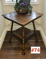 Front view of the antique ash parlour table showing the square top, turned legs, and lower shelf with potted plant on top.