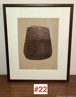 Framed copper relief artwork titled 'Tut' displayed on a wooden surface.