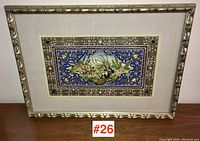 Framed Indo-Persian painting on tagua nut panel shown front-facing on table, full view.