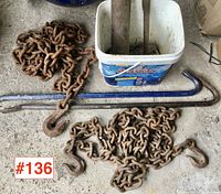 Two rusted tow chains with hooks, two blue crow bars, and a white bucket grease gun lubricant container with grease gun parts inside