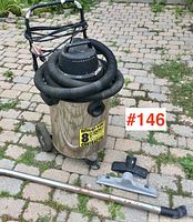 Full view of the stainless steel 8-gallon Shop-Vac with hose around top and accessories laid out in front.