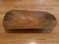 Top-down view of the full rectangular wooden bowl on hardwood floor.