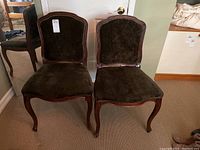 Pair of two wood-framed chairs upholstered in dark brown fabric, front view