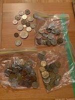 Coins spread on tabletop including various sizes and metals from different countries